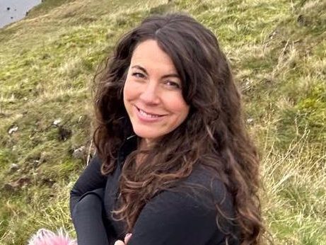 Photo of Harriet Pierpoint sitting on grassy bank.